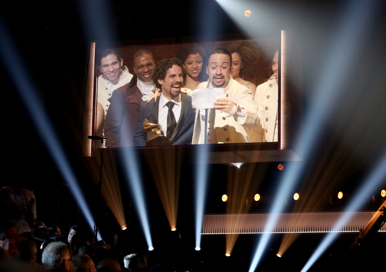 Lin-Manuel Miranda, right, appears on screen accepting the award for best musical theater album for Hamilton at the 58th annual Grammy Awards on Monday, Feb. 15, 2016, in Los Angeles. (Matt Sayles/Invision/AP)