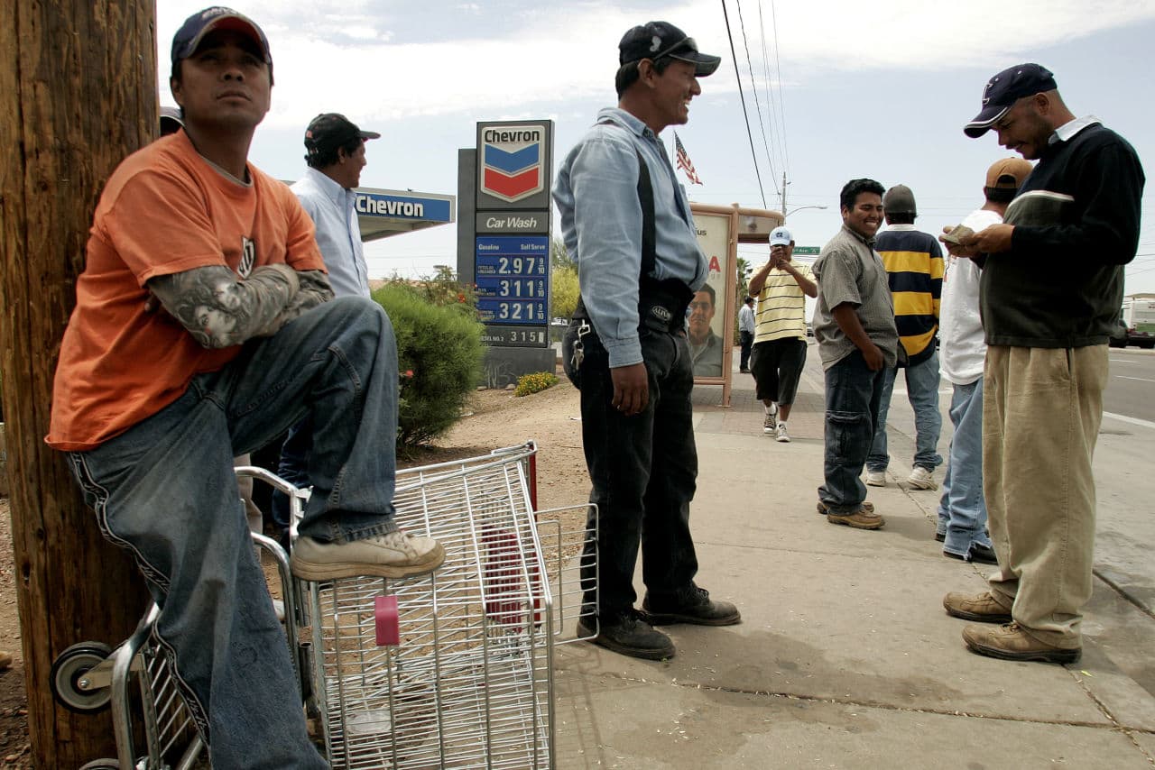 Day laborers wait for work near a Home Depot store in Phoenix in April of 2006. (Khampha Bouaphanh/AP)