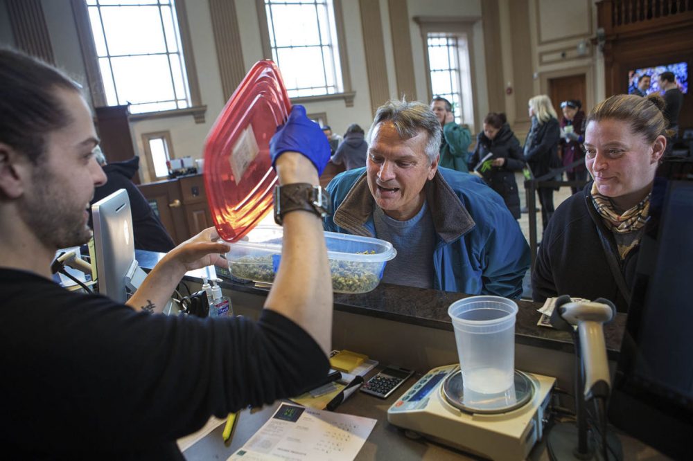 Before purchasing the Facewreck marijuana flower, Gene Wackrow checks out the product. (Jesse Costa/WBUR)