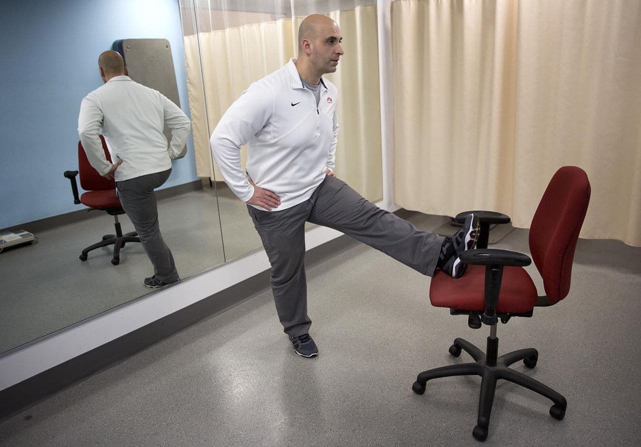 Fitness expert Rick DiScipio demonstrates a hamstring stretch. (Robin Lubbock/WBUR)
