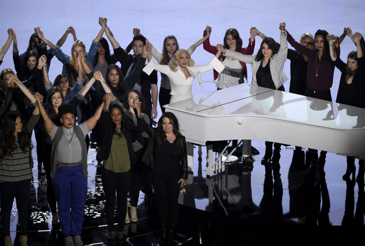 Lady Gaga, center, performs "Til It Happens To You" that was nominated for best original song from "The Hunting Ground" on stage with survivors of abuse at the Oscars. (Chris Pizzello/Invision/AP)