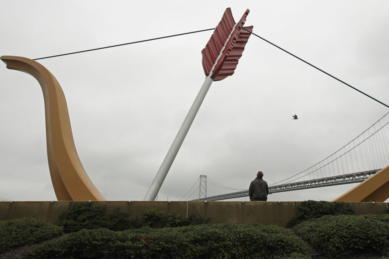 Overcast sky surrounds a man as he rests beneath the art sculpture 'Cupids Span' Wednesday, Dec. 5, 2012 at Rincon Park in San Francisco. The Bay area has endured unsettled, rainy weather for a week. (AP Photo/Ben Margot)