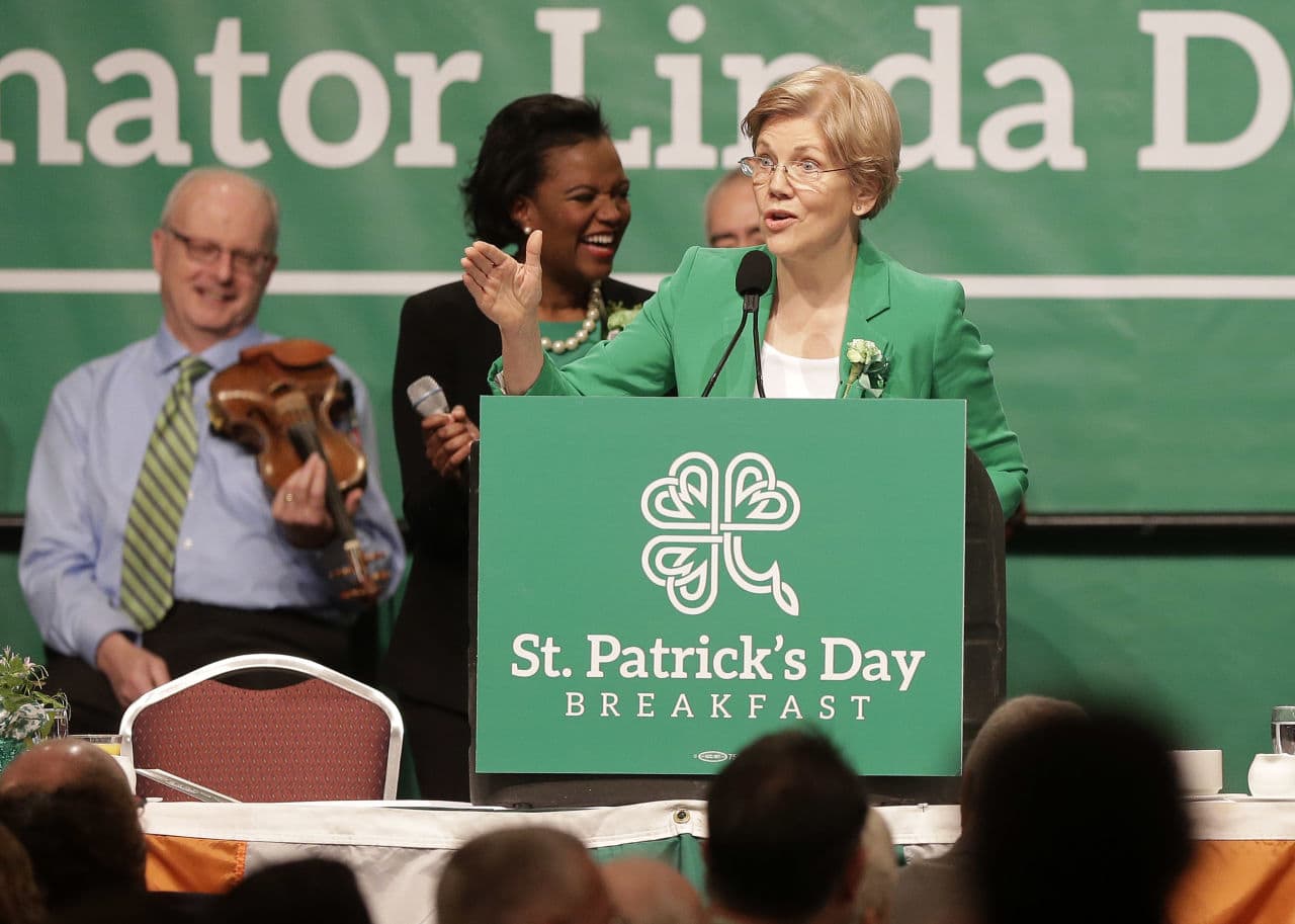 U.S. Sen. Elizabeth Warren, D-Mass., right, jokes with the audience as Mass. state Sen. Linda Dorcena Forry, D-Dorchester, behind center, laughs during the annual St. Patrick's Day Breakfast on Sunday. (Steven Senne/AP)