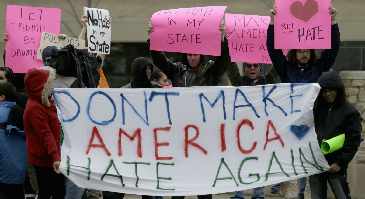 Protesters hold signs on the street in Appleton, Wis., Wednesday, March 30, 2016, where Republican presidential candidate Donald Trump appeared for a rally. (Nam Y. Huh/AP)