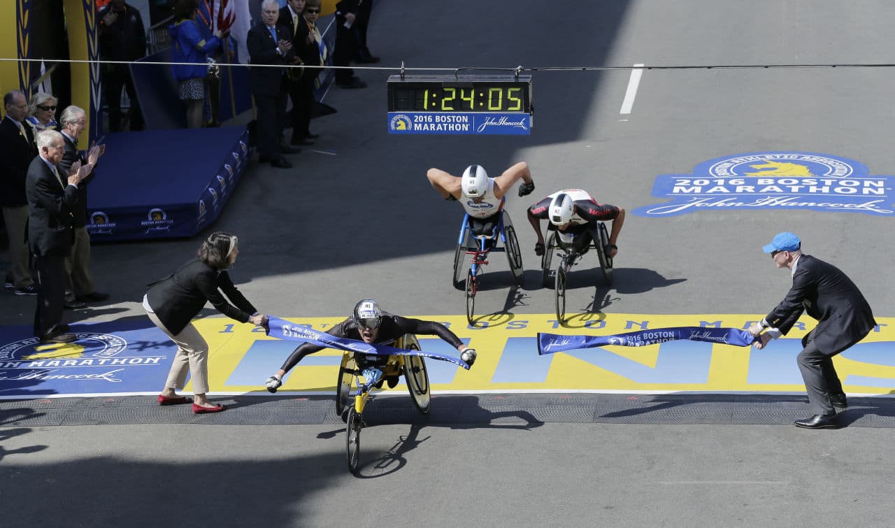 Marcel Hug of Switzerland breaks the tape ahead of Kurt Fearnley, of Australia, center, and Ernst Van Dyk, of South Africa, in the wheelchair division of the 120th Boston Marathon on Monday, April 18, 2016, in Boston. (Charles Krupa/AP)