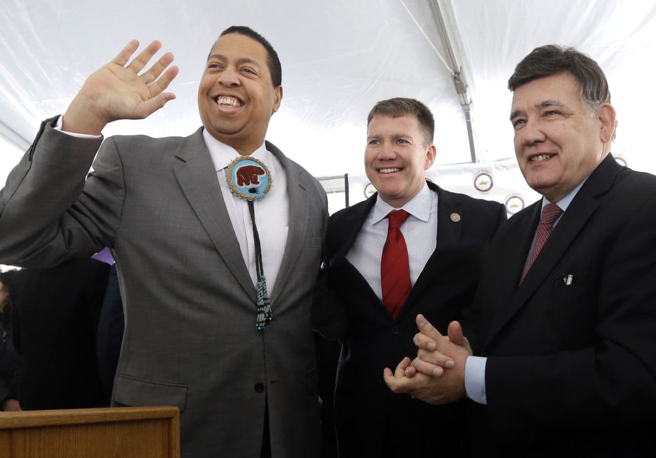 Tribal Chairman Cedric Cromwell waves as Taunton Mayor Thomas Hoye, center, and state Sen. Marc Pacheco look on before an official groundbreaking on Tuesday where the Mashpee Wampanoag tribe will build a resort casino. (Elise Amendola/AP)