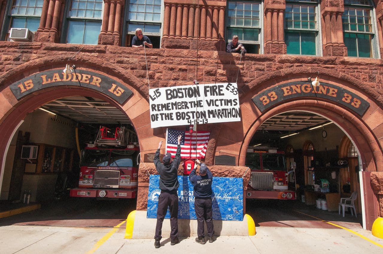 Boston firefighters raise a banner in honor of the victims one week after the bombings in 2013 at the firehouse closest to the attack. (Courtesy Joshua Touster)