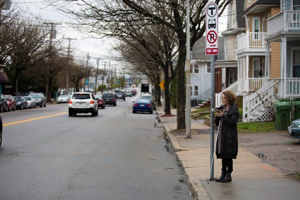 Joann Becker stands at a Watertown bus stop, which she hopes will be easier for visually impaired people to locate with a new mobile app she's working on at the Perkins School for the Blind. (Jesse Costa/WBUR)