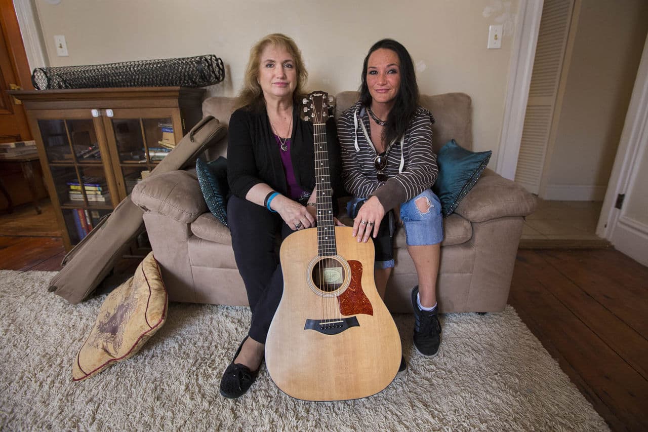 Kathy Carlsen and Heather McQueen sit with Kathy's son's guitar, which Heather tracked down, knowing how much it meant to her. (Jesse Costa/WBUR)