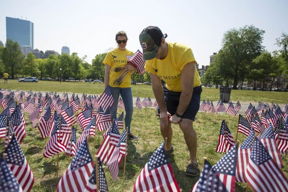 Victoria Hay and Scott Zerneri, volunteers from BNY Mellon, spend a couple of hours planting flags ahead of Thursday's ceremony. (Jesse Costa/WBUR)