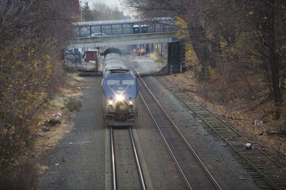 The Amtrak Downeaster barrels down the tracks. The tracks of the corridor for the proposed Green Line Extension which run through Somerville and Medford already serves MBTA Commuter Rail and Amtrak trains. (Jesse Costa/WBUR)