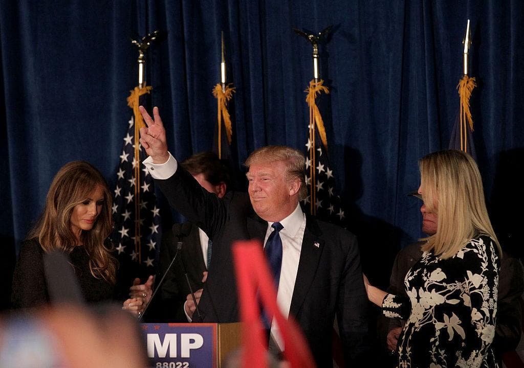 Republican presidential candidate Donald Trump waves after speaking as his wife Melania Trump and daughter Ivanka Trump look on at his election night watch party at the Executive Court Banquet facility on February 9, 2016 in Manchester, New Hampshire. (Matthew Cavanaugh/Getty Images)
