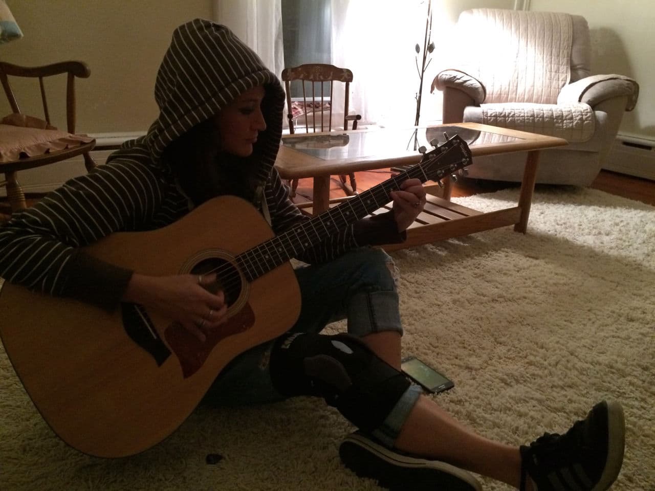 Heather McQueen plays James Carlsen's guitar for the first time. (Erika Lantz/WBUR)