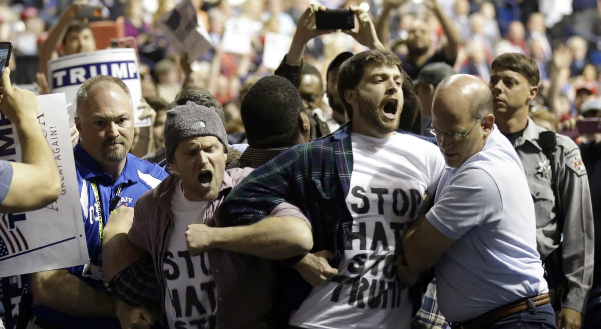 Joelle Renstrom: "Has Trump’s venom so poisoned the national dialogue that violence and vitriol have become standard currency?" Pictured: Protesters are removed as Republican presidential candidate Donald Trump speaks during a campaign rally in Fayetteville, N.C. in March, 2016. The scene was violent and chaotic. (Gerry Broome/AP)