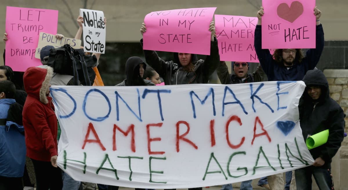 Steve Almond: "One of the central byproducts of Trump’s nomination has been a rush to label his supporters as ignorant racists in the thrall of a con man. Not only is that a dangerous oversimplification, it's counter-productive and hypocritical." Protesters of Donald Trump's presidential bid in Appleton, Wis., Wednesday, March 30, 2016. (Nam Y. Huh/AP)