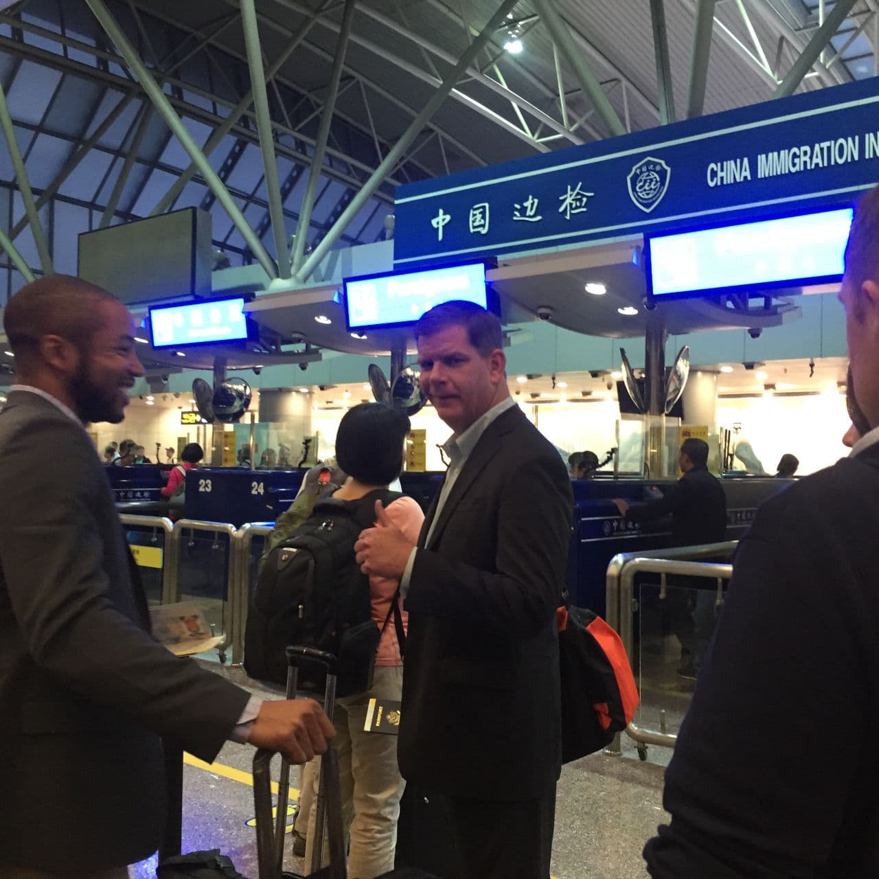 From left, Blackmon and Walsh at passport control in an airport in Beijing. (Bruce Gellerman/WBUR)