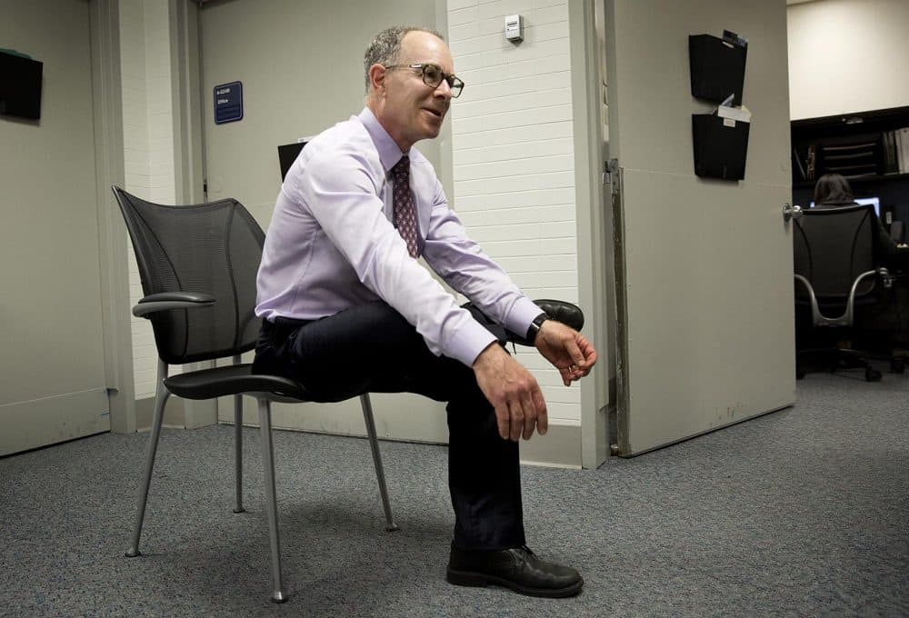 Dr. Eddie Phillips does a hip stretch at his office at the VA Boston Healthcare System. (Robin Lubbock/WBUR)