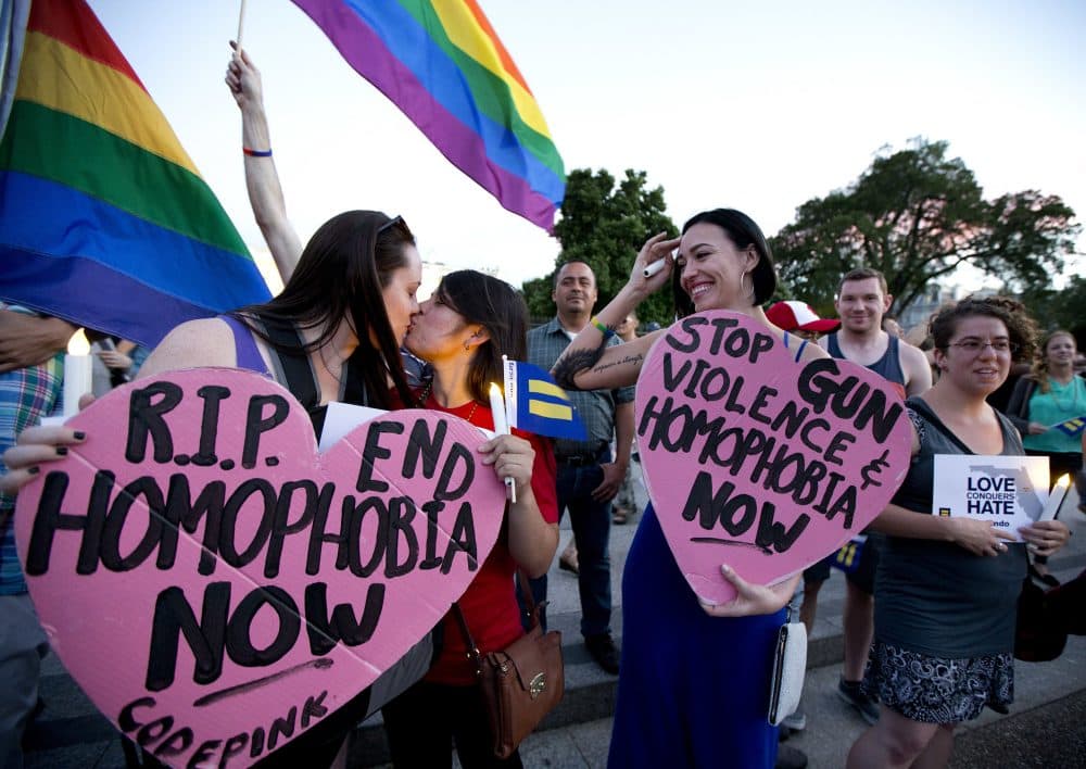 Rachel Henry, left, and Selene Arciga, kiss to show their solidarity with members and supporters of the LGBT gathered for a candlelight vigil in front of the White House in Washington. (Manuel Balce Ceneta/AP)