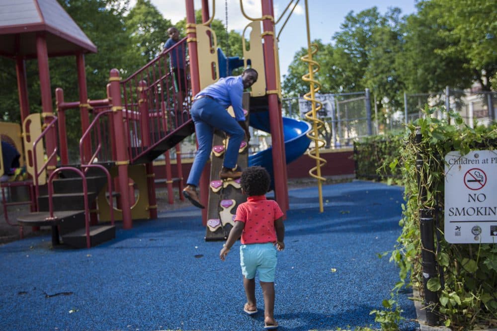 Charles Daniels plays with his one-year-old son Clayton in the Thetford Evans Playground in Dorchester. (Jesse Costa/WBUR)