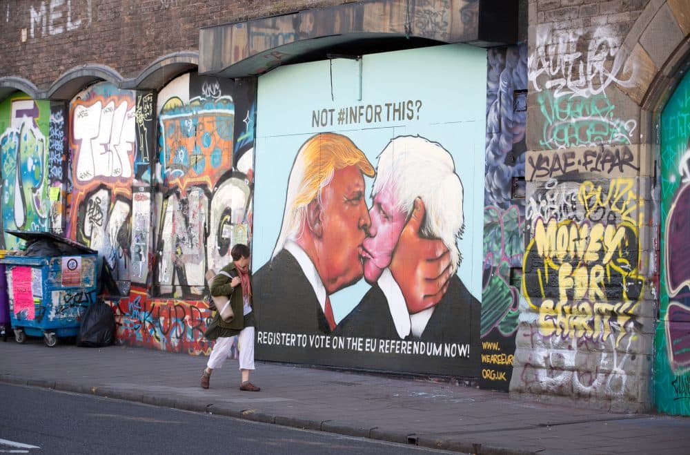 A woman passes a mural that has been painted on a derelict building in Stokes Croft showing US presidential hopeful Donald Trump sharing a kiss with former London Mayor Boris Johnson on May 24, 2016 in Bristol, England. Boris Johnson is currently one of the biggest names leading the campaign for Britain to leave the European Union in the referendum which takes place on June 23 and Republican presidential hopeful Donald Trump has also backed a so-called Brexit.  (Matt Cardy/Getty Images)