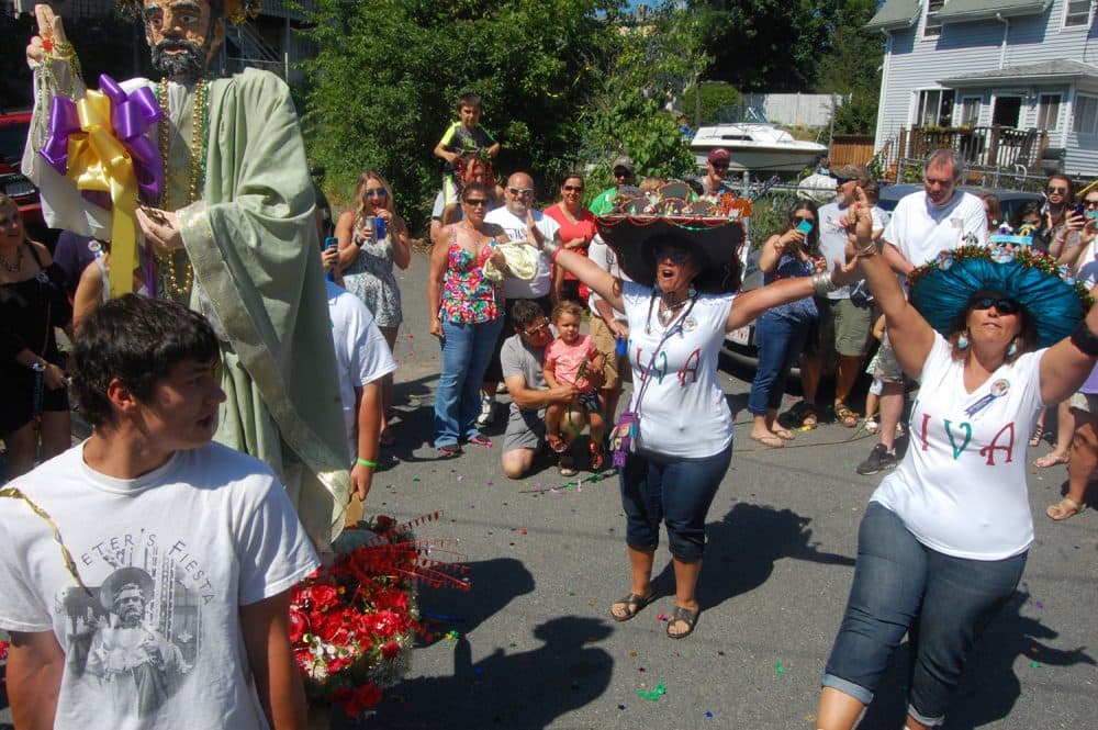 Jacob Belcher carries a replica of the Fiesta’s St. Peter statue during the “Orchard Street Annual Fiesta Celebration” on Saturday, June 25, 2016. The celebration—a mini Fiesta within the larger festival—was founded by his aunt Robyn McNair (center) and his mother Amy Belcher, who are known as the “Crazy Hat Ladies” for the elaborate headgear they make and wear to the Fiesta each year featuring miniature replicas of Fiesta landmarks. (Greg Cook)