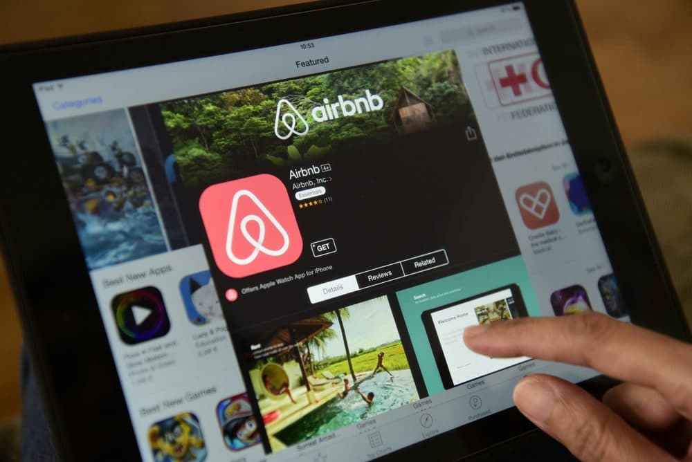 A woman browses the site of U.S. home sharing giant Airbnb on a tablet in Berlin on April 28, 2016. (John MacDougall/AFP/Getty Images)