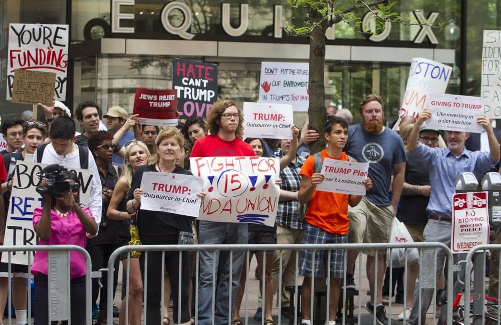 People gathered on Franklin Street hold signs reading &quot;Hate Can't Trump Love&quot; and &quot;Giving to Trump: Like investing in a slot machine.&quot; (Joe Difazio for WBUR)