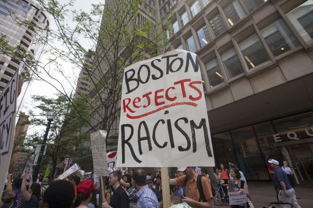 Demonstrators held signs and chanted outside The Langham Wednesday. (Joe Difazio for WBUR)
