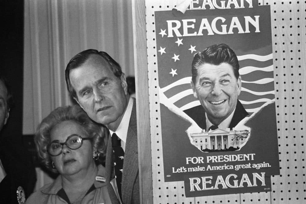 George Bush peeks around a partition which has a poster of Ronald Reagan, one of his opponents for the Republican party presidential nomination, before he speaks at at the Richland Country GOP convention in South Carolina on March 4, 1980. (AP)