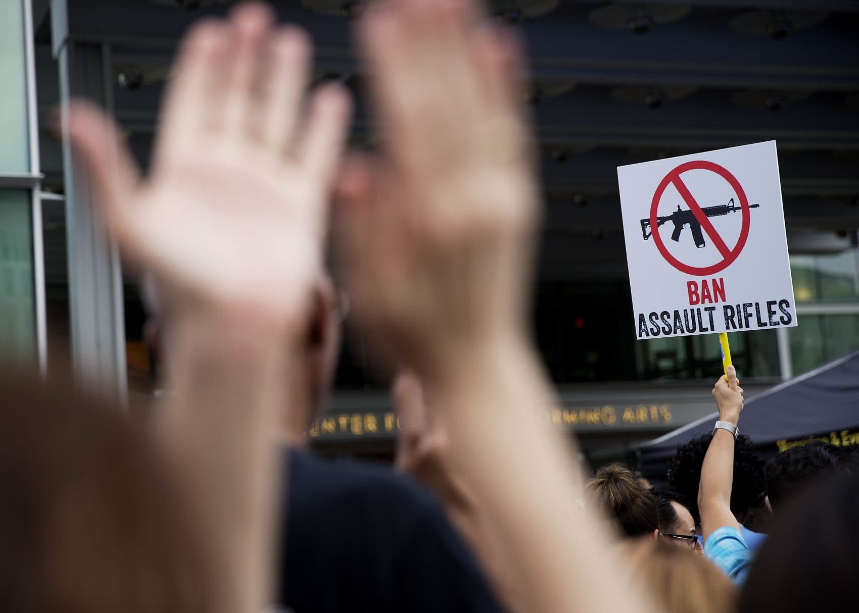 A crowd member holds up a sign as audience members applaud during a speech at a vigil downtown for those killed in a mass shooting at the Pulse nightclub Monday, June 13, 2016, in Orlando, Fla. It was the deadliest mass shooting in modern U.S. history. (David Goldman/AP)