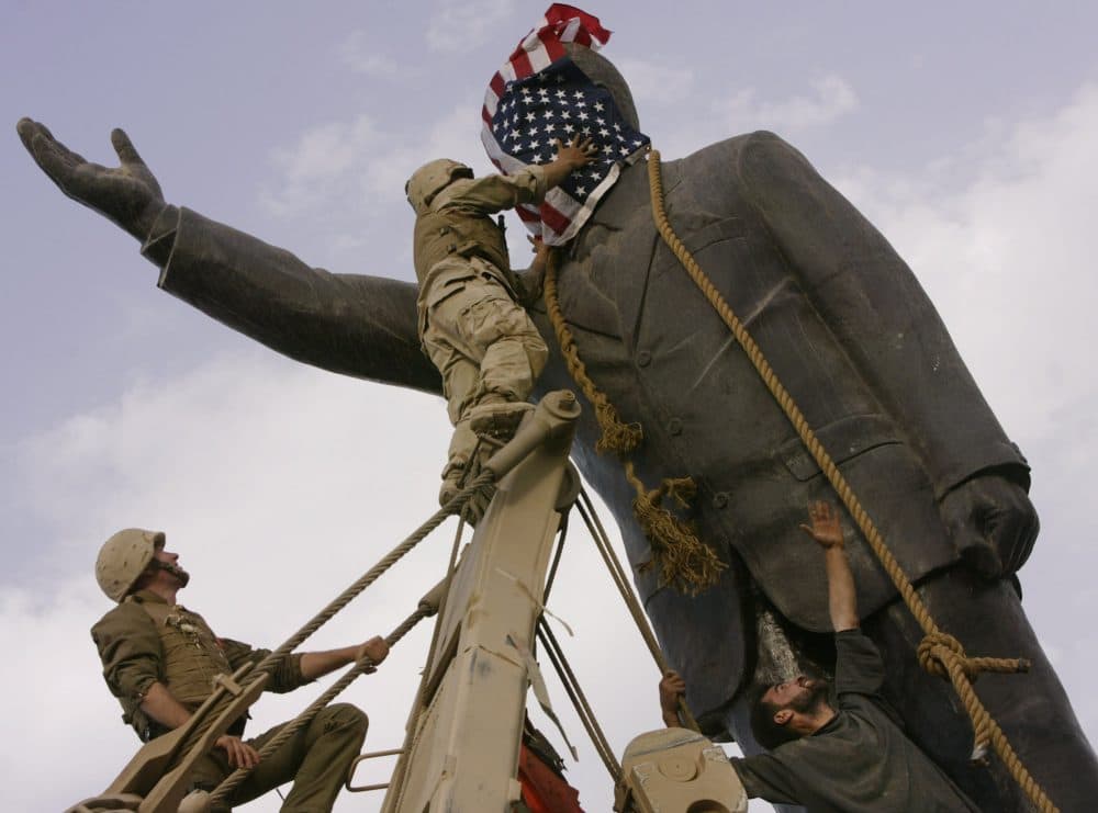 Neta C. Crawford does the math and asks: Has the War on Terror been money well spent?  Pictured: Wednesday, April 9, 2003, an Iraqi man, bottom right, watches Cpl. Edward Chin of the 3rd Battalion, 4th Marines Regiment, cover the face of a statue of Saddam Hussein with an American flag before toppling the statue in downtown in Baghdad, Iraq. Thirten years after the U.S. invaded Iraq to topple Saddam Hussein, the country is still mired in war. (Jerome Delay/AP File)
