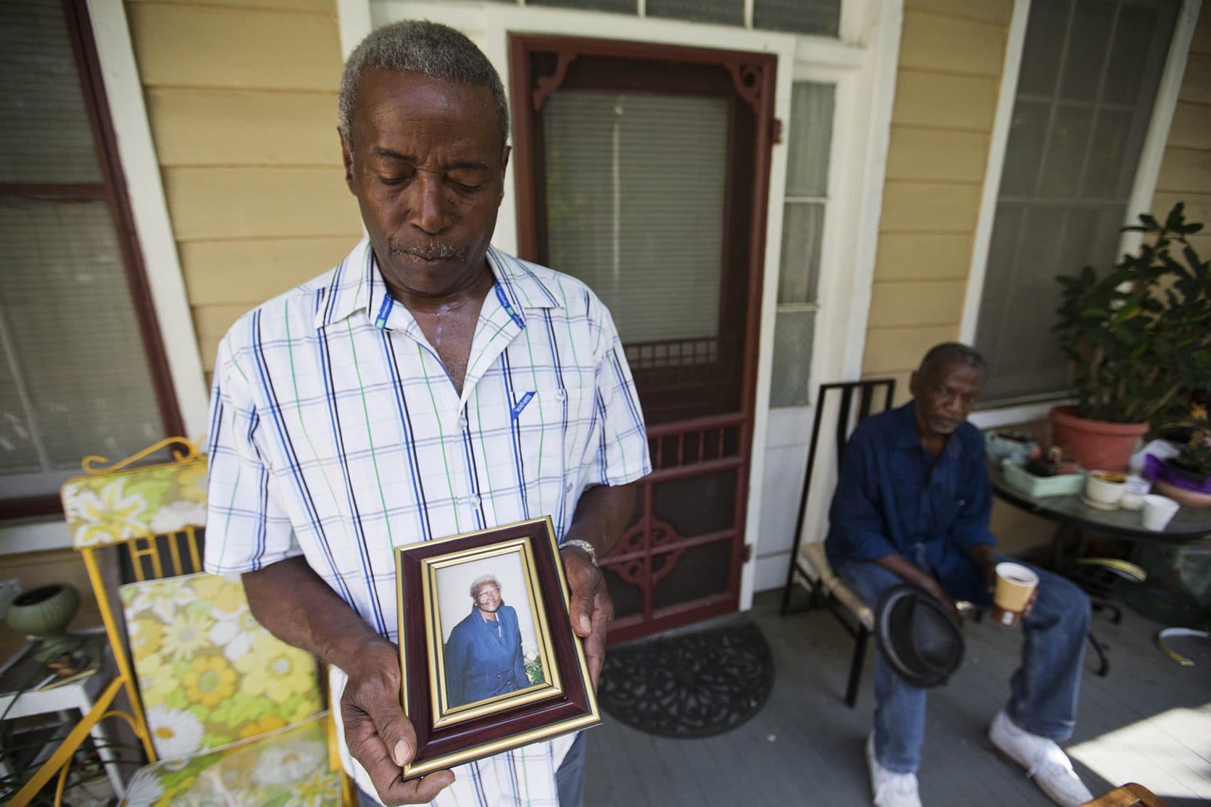 Walter Jackson, left, holds a photo of his mother Susie Jackson, one of the nine people killed in Wednesday's shooting at Emanuel AME Church, while standing for a portrait on his front porch as his cousin Kenneth Washington, right, looks on Friday, June 19, 2015, in Charleston, S.C. &quot;Right now all in my heart is anger for him,&quot; said Jackson. &quot;I doubt if I'll ever forgive him.&quot; (David Goldman/AP)
