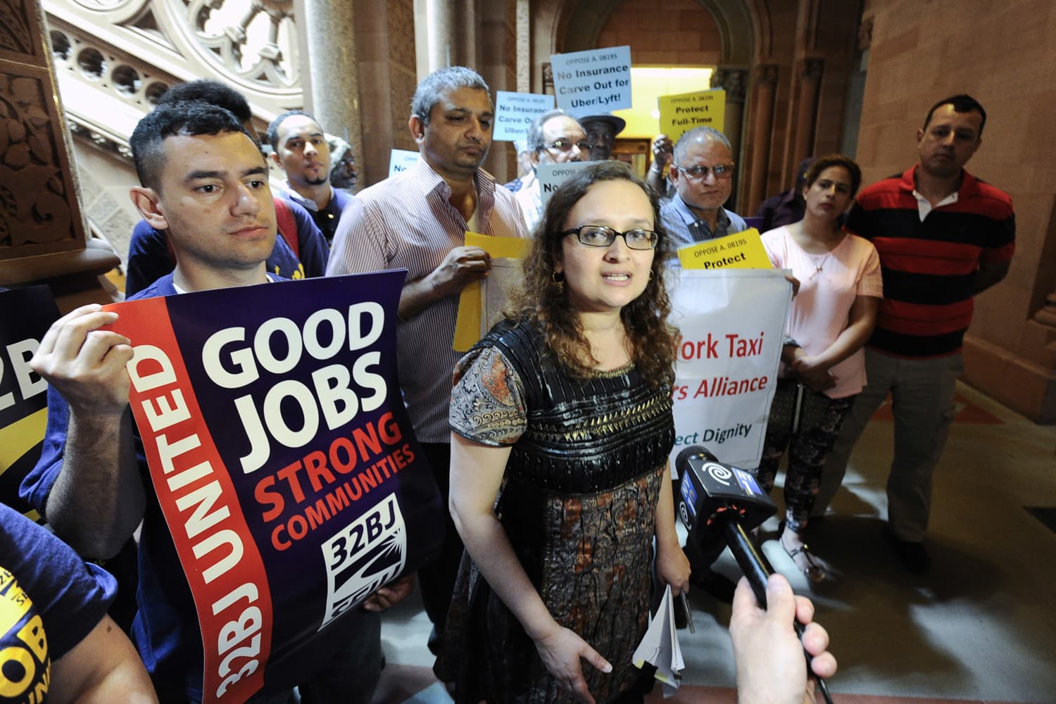 Bhairavi Desai, executive director of the New York Taxi Workers Alliance, center, speaks against allowing Uber and other app-based drivers to expand service to upstate New York at the state Capitol in Albany, N.Y. (Hans Pennink/AP)