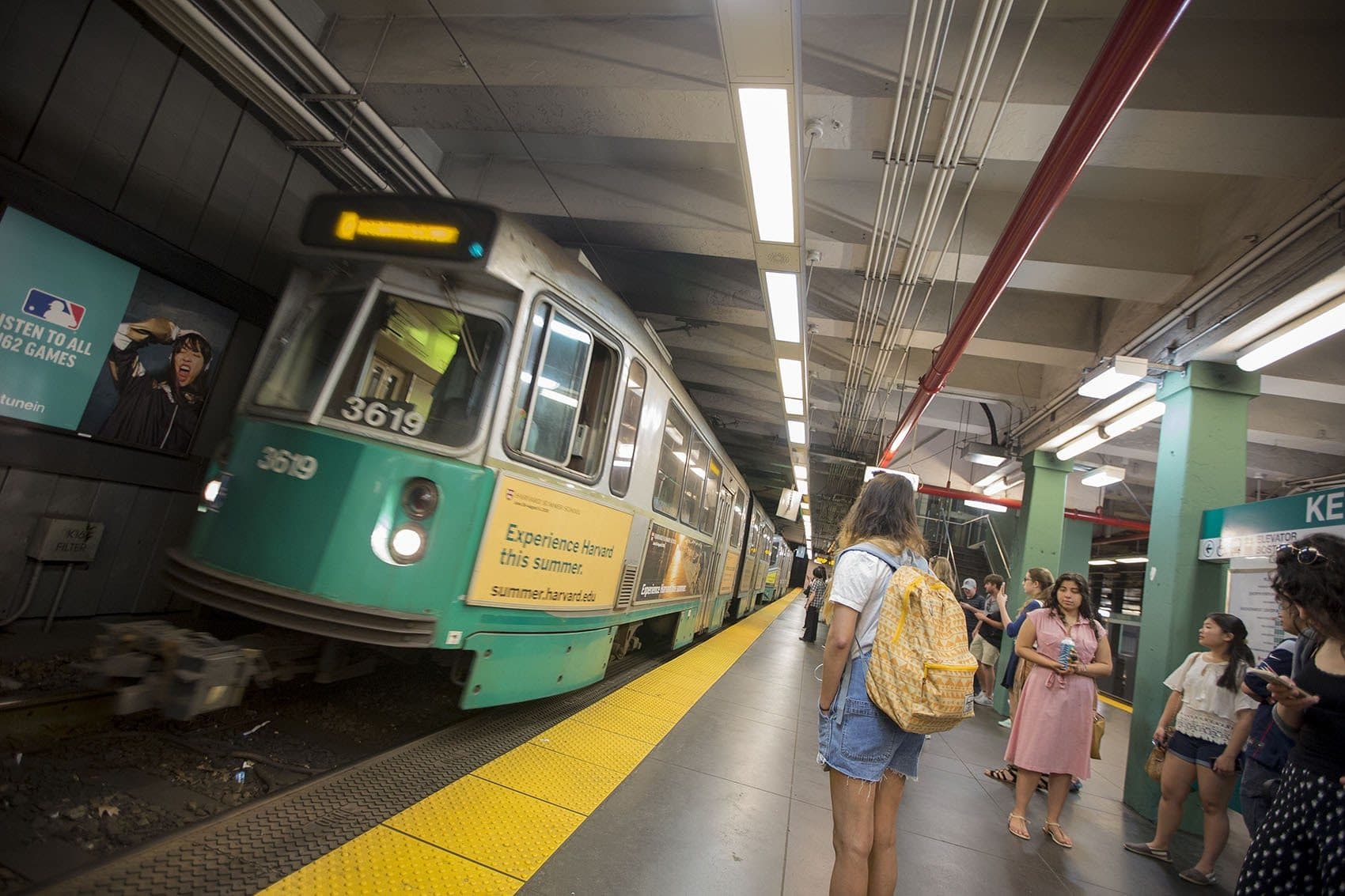 Passengers wait for a MBTA Green Line trolley to pull into Kenmore Station. (Jesse Costa/WBUR)