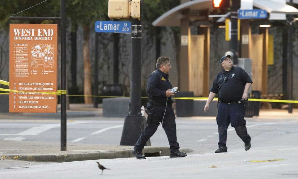 Investigators survey the area after a shooting in downtown Dallas on Friday. (LM Otero/AP)