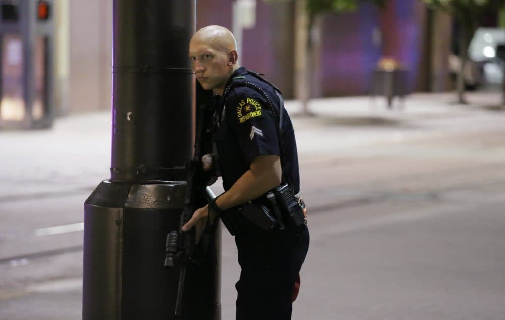A Dallas policeman keeps watch on a street in downtown Dallas Thursday, following reports that shots were fired during a protest over two recent fatal police shootings of black men. (LM Otero/AP)