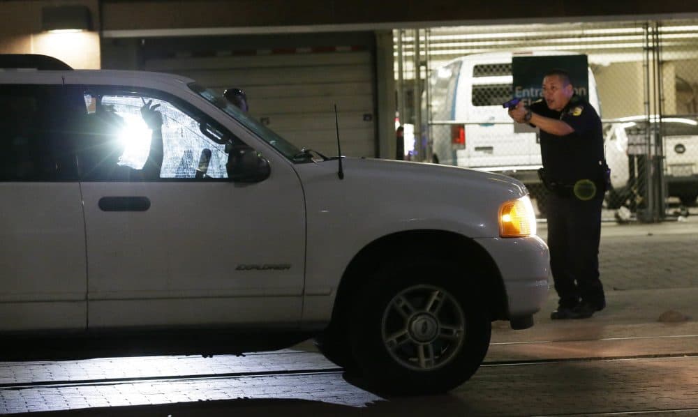 Dallas police stop a driver in downtown Dallas Thursday night, following shootings of police officers. (LM Otero/AP)
