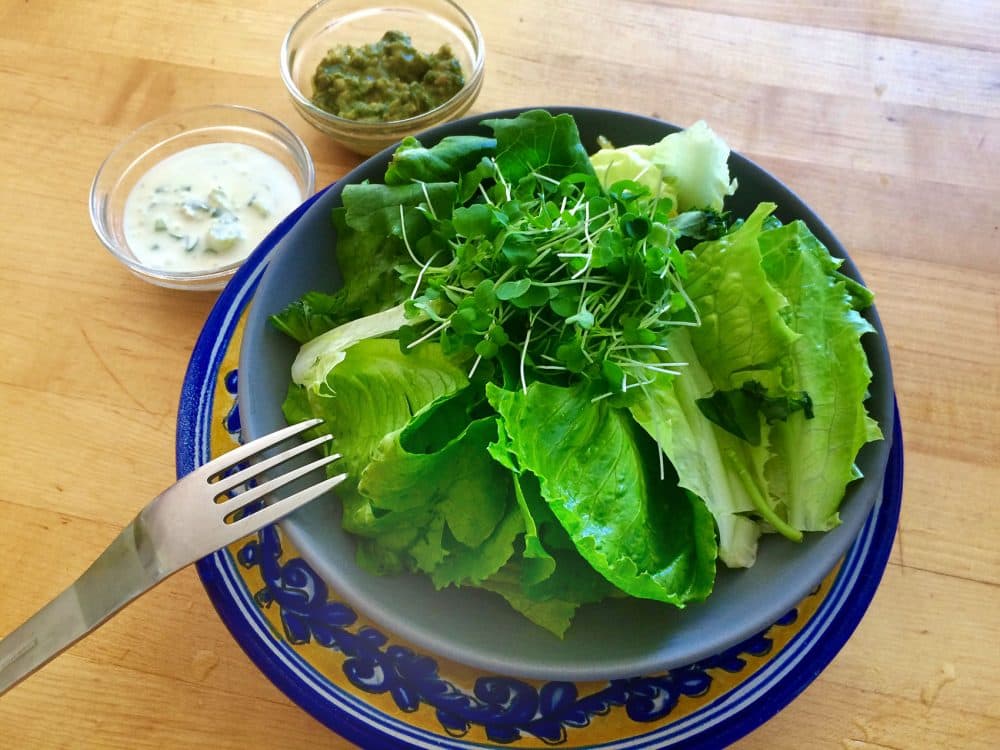 Garden romaine lettuce with Kathy's buttermilk blue cheese dressing (top left) and pesto dressing (top right) on side. (Kathy Gunst for Here & Now)