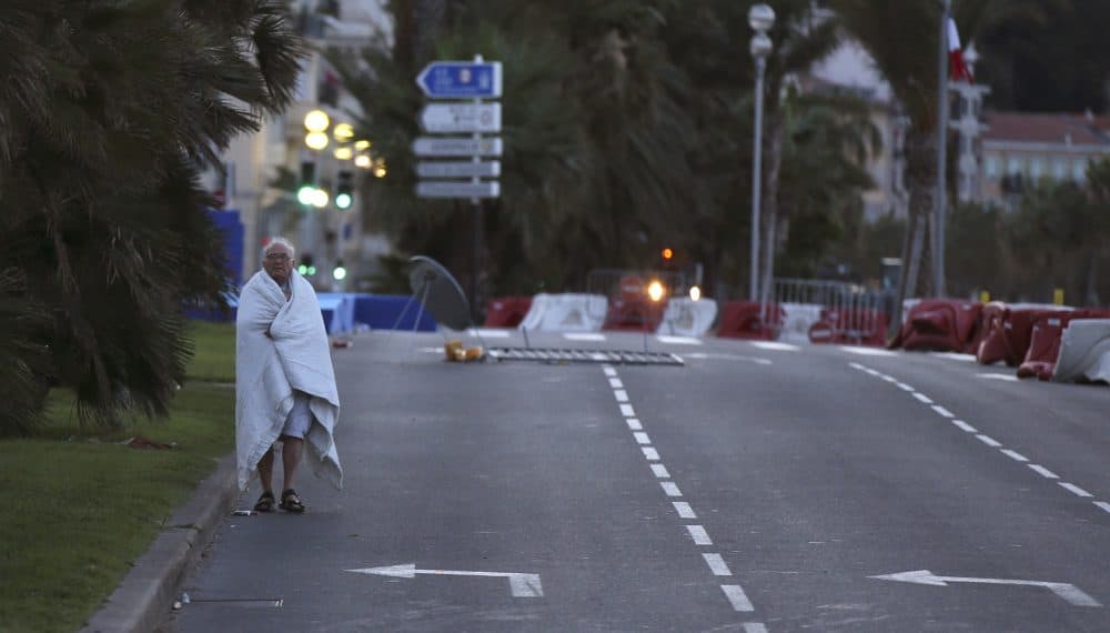 A man walks near the scene of an attack after a truck drove onto the sidewalk late Thursday, July 14, and plowed through a crowd of revelers who'd gathered to watch the fireworks in the French resort city of Nice, southern France, Friday, July 15, 2016. (AP Photo/Luca Bruno)
