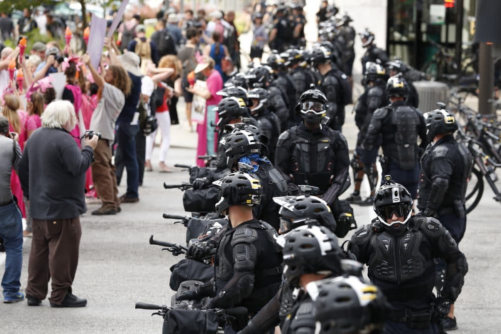 Demonstrators march by police during the Shut Down Trump &amp; the RNC protest on Sunday in Cleveland. (Alex Brandon/AP)