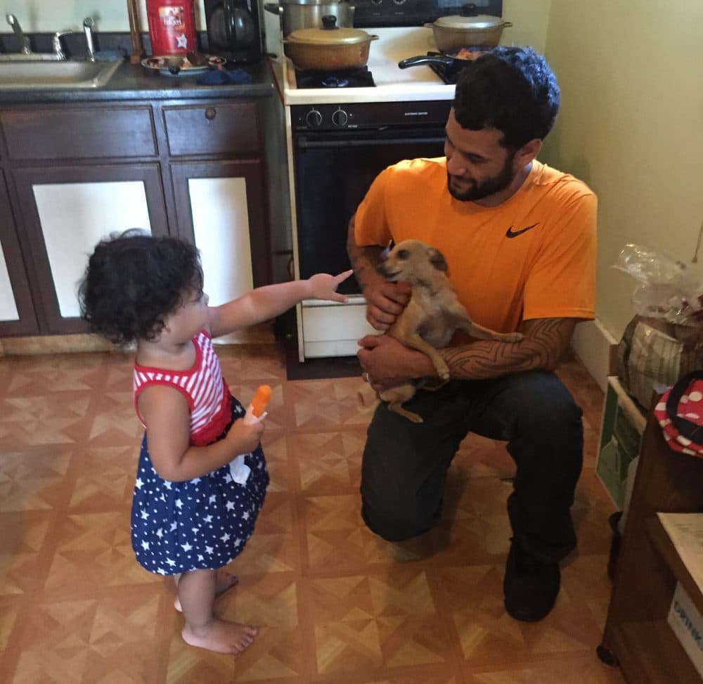 Juan Rivera plays with his daughter Zahira in the kitchen of their Cleveland home. (Robin Young/Here &amp; Now)