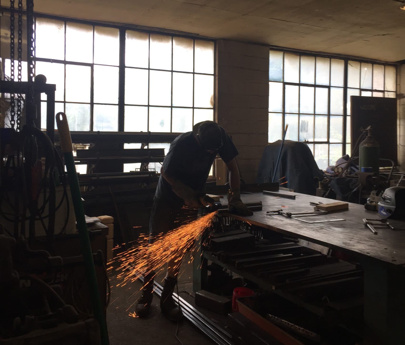 Sparks fly as a welder works in the Cleveland Art workshop. (Robin Young/Here &amp; Now)
