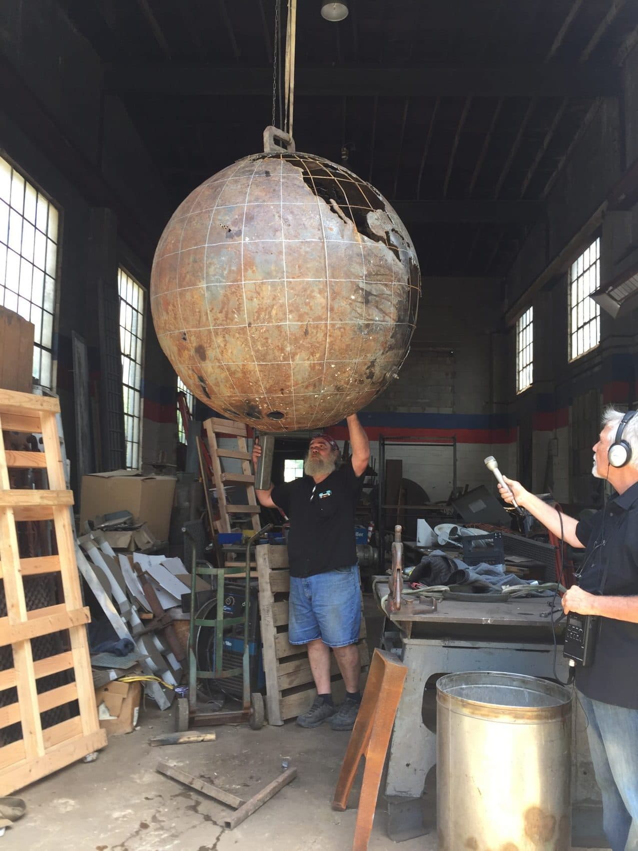 Cleveland Art manager Bart Hanick shows off a buoy, which has been turned into a globe, to Here &amp; Now producer Chris Ballman (right). (Robin Young/Here &amp; Now)