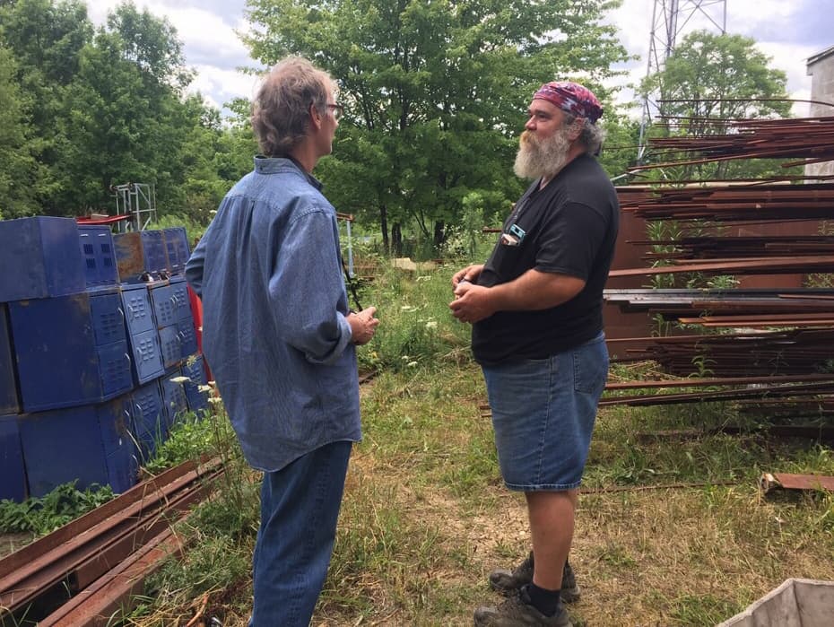 Cleveland Art manager Bart Harnick speaks with Here &amp; Now producer Alex Ashlock in the yard behind the glassblowing facility. (Robin Young/Here &amp; Now)