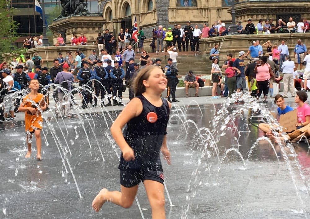 Ten-year-old Bella Stofey and her brother Jimmy played in the Public Square fountain during one of the largest protests held in Cleveland on the last day of the RNC. (Shannon Dooling/WBUR)