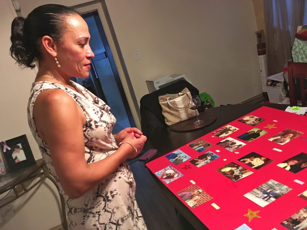 Anita Colon looks at photos of her brother Robert and other family members when he was younger. (Sam Fields/Here &amp; Now)