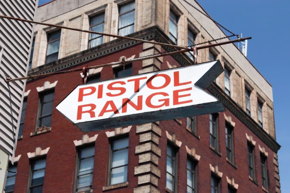 A sign on the corner of Spring Garden Street and North Percy Street points pedestrians to The Gun Range in North Philadelphia. (Dean Russell/Here & Now)