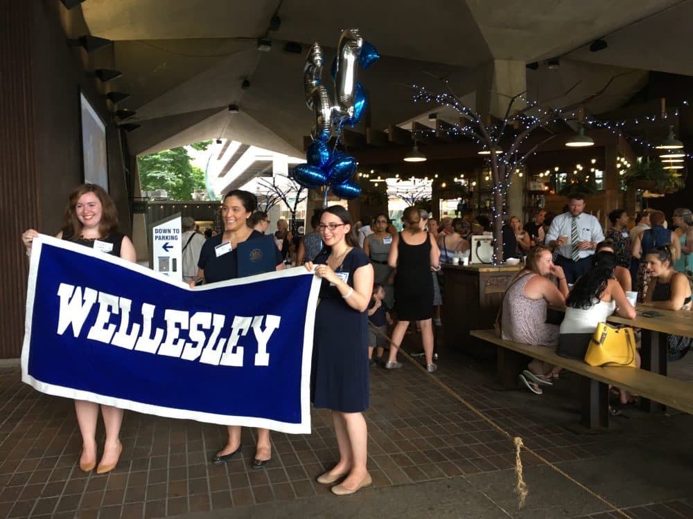 Women at the Philadelphia Wellesley College Club hold up a sign at a celebration for Hillary Clinton's nomination. (Samantha Fields/Here &amp; Now)