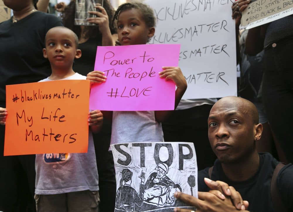 Jashaun Sadler, right, and his twins Malik, left, and Jazlin Sadler listen to speakers during a Black Lives Matter demonstration in New York, Sunday, July 10, 2016. A crowd of about 300 people protested against the shootings of black men by police officers. (Seth Wenig/AP)