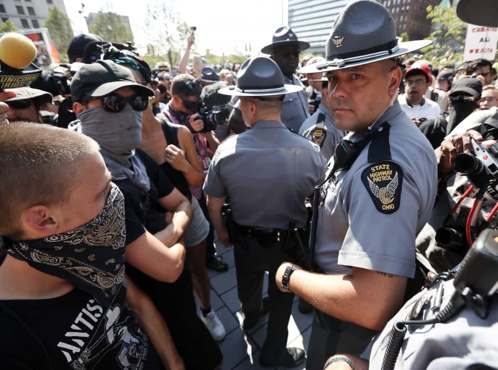 A protester watches as police move into Cleveland's Public Square Tuesday. (John Minchillo/AP)